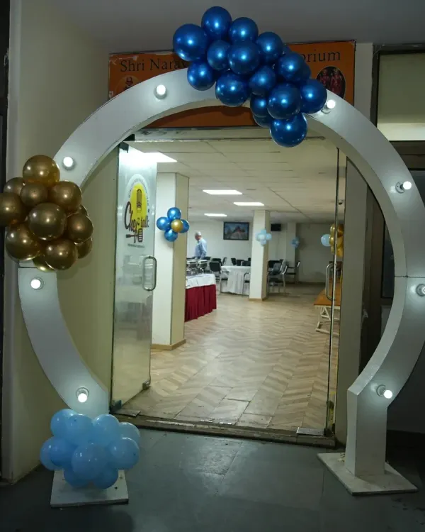 A modern and stylish circular entrance arch with built-in lights. Decorated with blue and gold balloon clusters, it creates an impressive entryway for any birthday party or event.