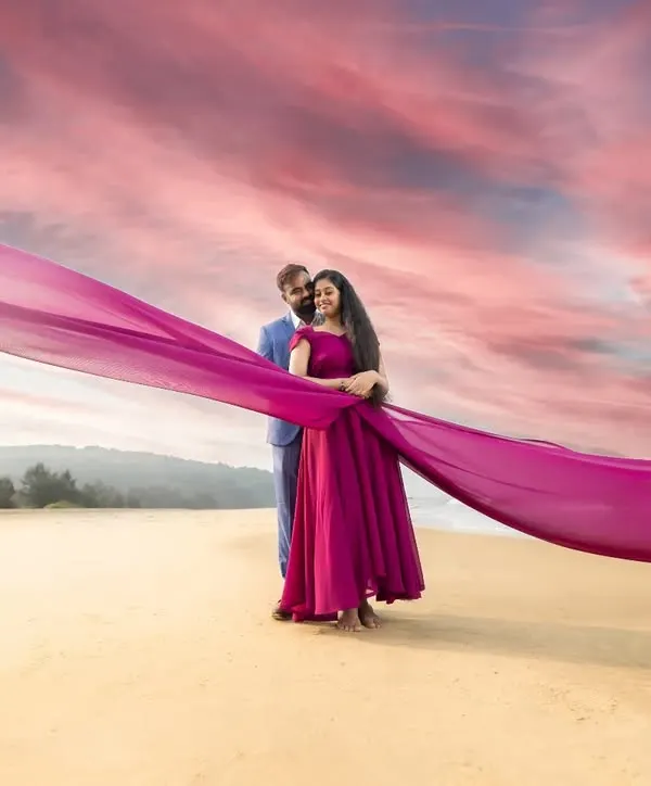 A dramatic beach portrait using a flowing magenta fabric to paint the sky. We love playing with colour and movement to create pre-wedding photos that feel like a work of art.