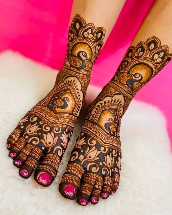 A high-quality, clear shot of beautiful foot mehndi, featuring elegant peacock and lotus motifs that are perfect for a bride.