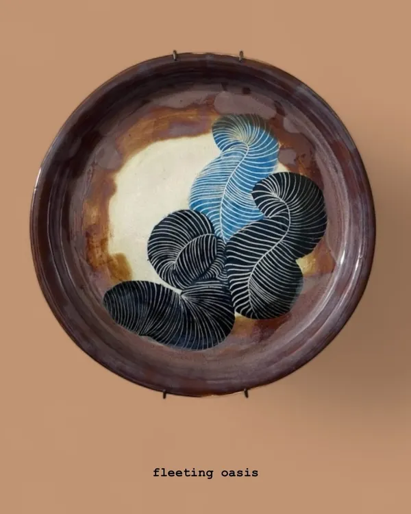 Titled 'Fleeting Oasis', this large sgraffito wall plate features abstract, feather-like forms. It’s a piece of ceramic art that plays with pattern and earthy tones, designed to be a contemplative focal point in any room.