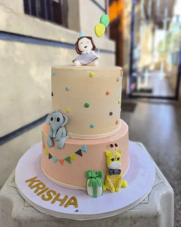 I love bringing imagination to life with cakes like this two-tiered birthday creation. It features adorable, hand-sculpted fondant animals like a baby elephant and giraffe, perfect for a whimsical celebration for your little one.