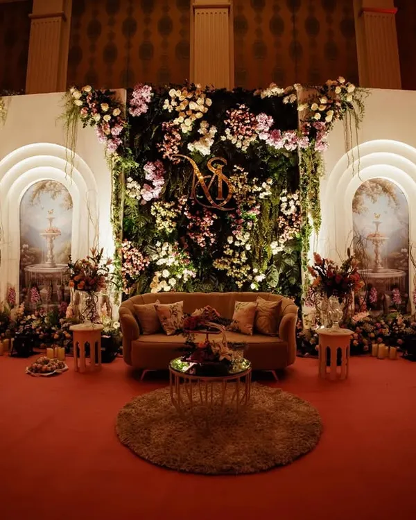 I designed this stage to feel like a secret garden brought indoors. A wall of cascading florals and glowing arches framed the couple's seating, creating an enchanting and romantic backdrop for their ring ceremony.