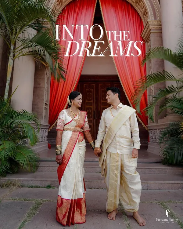 A grand portrait of the couple in traditional South Indian wedding attire, standing before a magnificent entrance. This shot, titled "Into the Dreams," captures the beginning of their new life together.