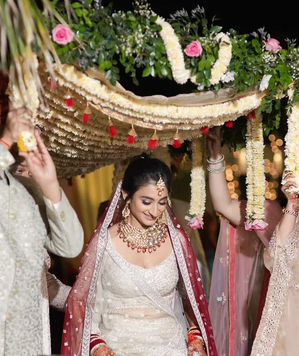 The beautiful bridal entry. Surrounded by her brothers and sisters under a floral phoolon ki chadar, the bride walks towards her new beginning with a gentle smile.