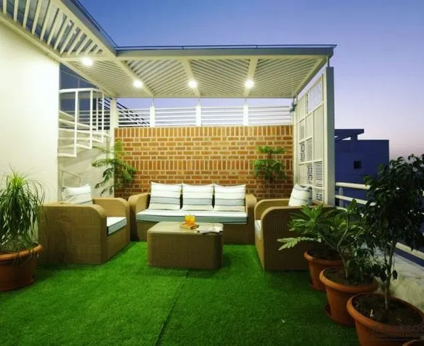 This terrace was designed as a complete outdoor living room. I installed a no-maintenance artificial lawn and added comfortable wicker furniture under a protective pergola, creating a perfect space for family time.