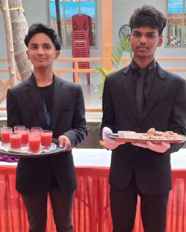 My young and energetic staff members serving welcome drinks and starters at a wedding in Pen. They are dressed in a clean, professional uniform.