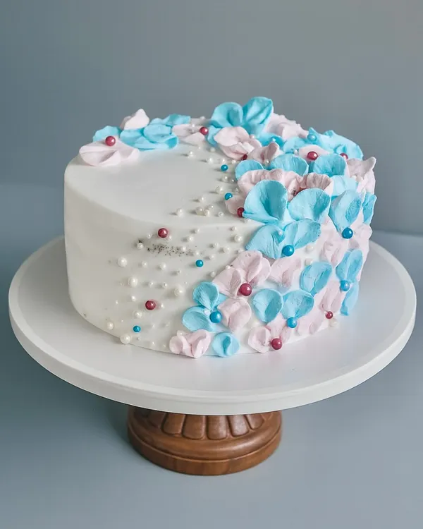 Welcoming a little bloom with a cake as delicate as the moment. This is a classic Black Forest cake wrapped in soft blue and pink florals for a very special baby shower.