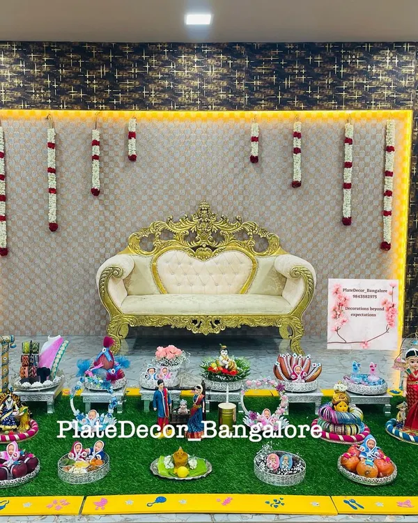This is a complete seer varisai setup I created, featuring a wide array of decorated platters on an artificial grass base with an elegant backdrop. It shows how I can manage and beautifully present a large number of ceremonial gifts.