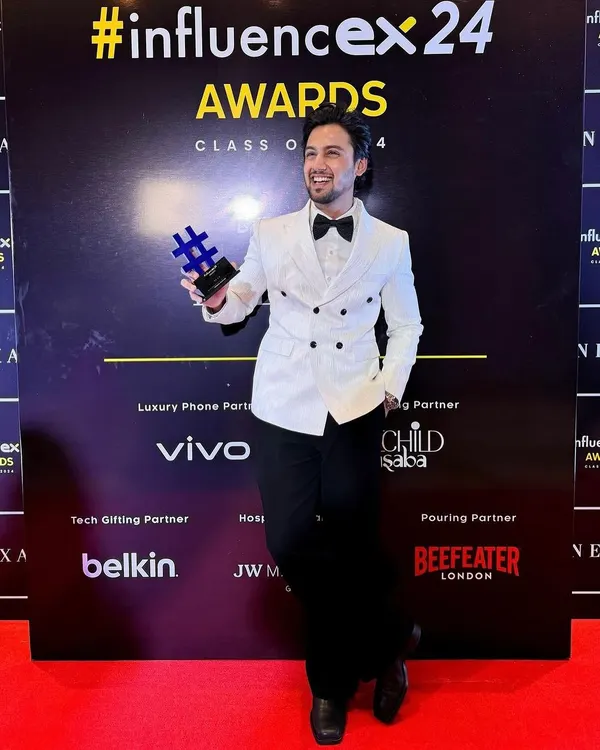 Our client Mohak Narang accepting the Best Influencer Award in a custom Levelline tuxedo. The white textured double-breasted blazer and black Japanese trousers create a sharp, award-winning look.