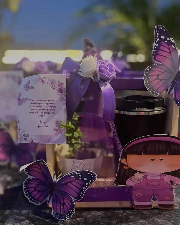 I love when parents choose thoughtful return gifts like these. This beautiful purple-themed gift box includes a small plant, showing that party favors can be both fun and meaningful.