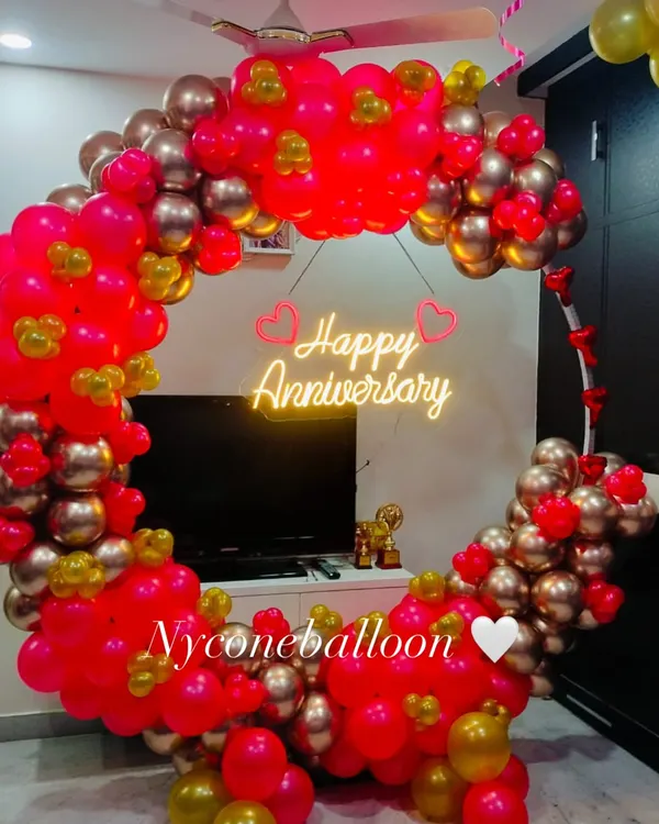 For a modern and stylish celebration, I create these circular balloon backdrops. This one uses a vibrant mix of pink and gold balloons and features a bright 'Happy Anniversary' neon sign, perfect for taking memorable photos.