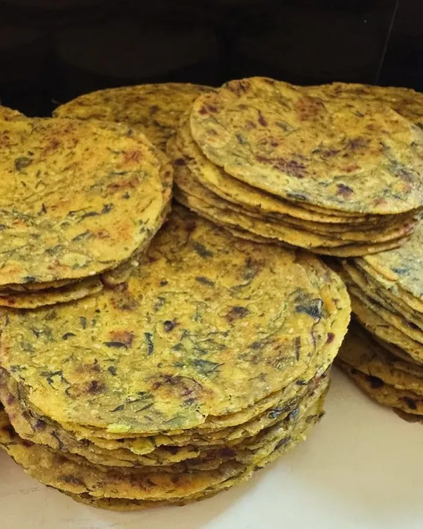 Stacks of freshly made Methi Theplas ready to be packed. These savory fenugreek flatbreads are a travel essential and a wholesome snack for any time of day.