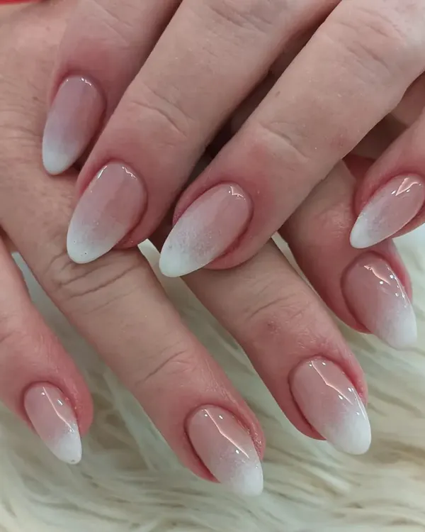 The perfect baby boomer ombré on elegant almond-shaped nails. This design features a seamless transition from a natural pink base to a soft white tip for a timeless and sophisticated look.