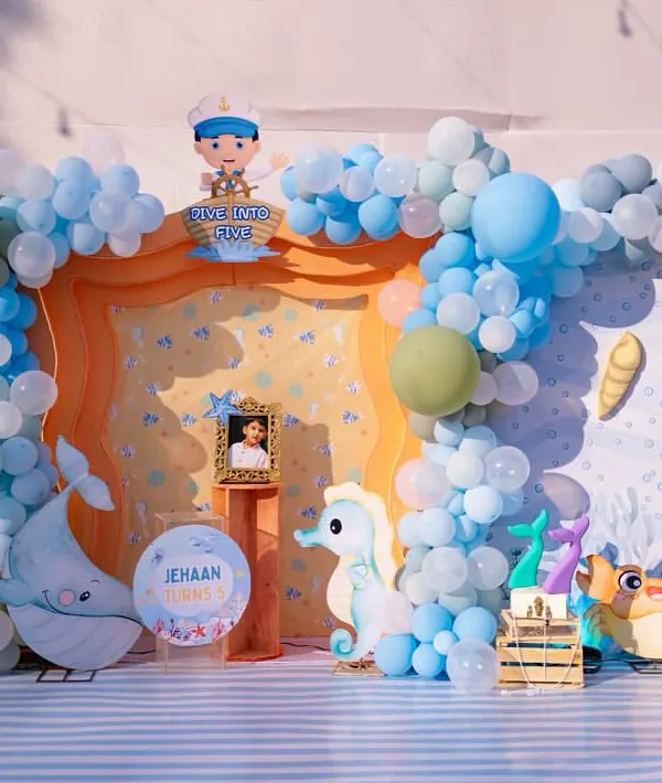 The complete 'Under the Sea' backdrop for Jehaan's 5th birthday. I used a palette of blues, whites, and seafoam green, incorporating elements like a whale, seahorse, crab, and a personalized photo of the birthday boy.