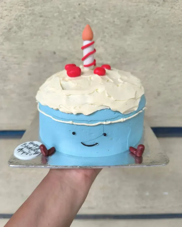 What a cutie. This adorable bento cake is designed to look like a smiling cartoon cake itself, complete with a little candle on top.