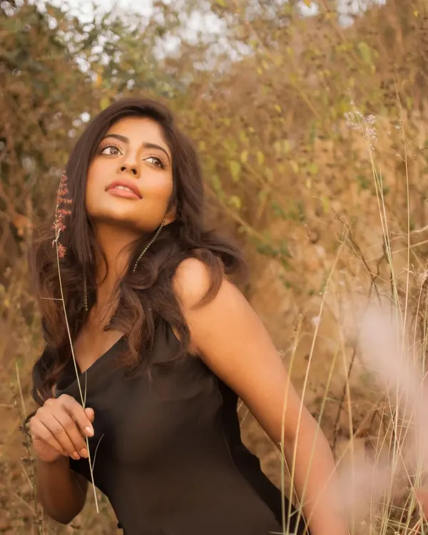A portrait taken in a field of tall, dry grass during the golden hour. The warm, diffused light creates a soft, dreamy atmosphere, perfect for a natural and romantic lifestyle shoot.