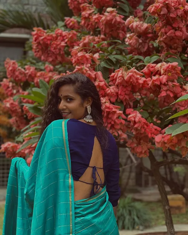 Feeling beautiful in this blue saree against a backdrop of lovely flowers.