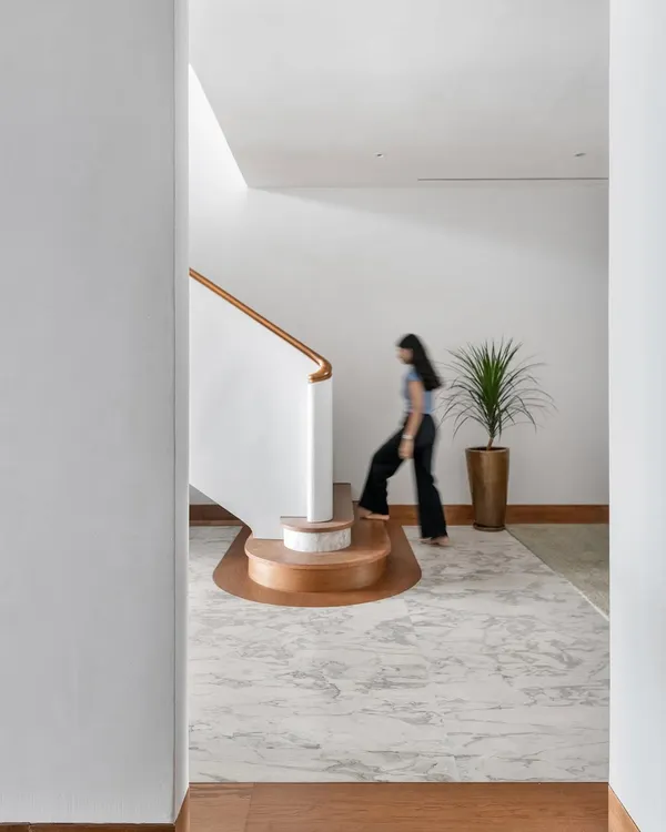 The winding staircase is the defining element of the Worli Duplex, its sculptural form anchoring the home's circulation. We designed its gentle curve to break the apartment's orthogonal geometry, creating a sense of fluid movement between the two levels.