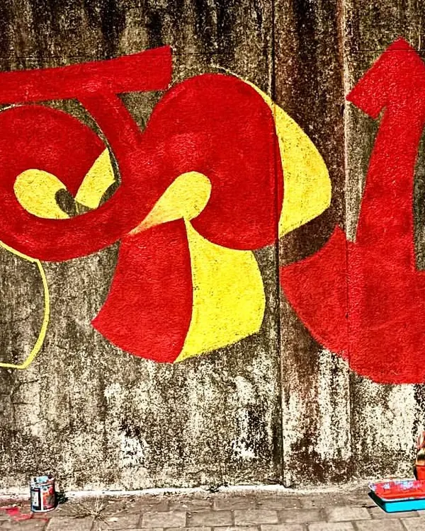 Aarela hai apun! Me painting my tag 'Vrek13' in bold Devanagari script on a weathered wall in my hometown, Bombay. This is street art with local flavor.