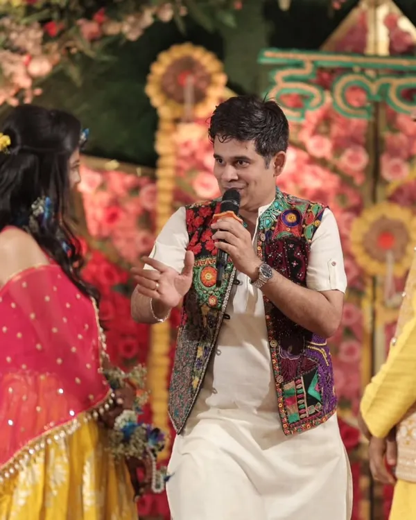 A candid shot from a Mehendi ceremony, sharing a laugh with the bride and groom. These are the real, unscripted moments that make a wedding special.