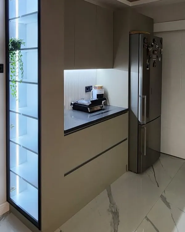 A tall, floor-to-ceiling crockery unit with a black frame and glass doors. The internal LED lighting beautifully illuminates the glassware and decor inside, turning everyday items into a stunning display.