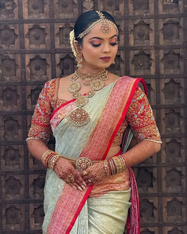 A complete bridal look showcasing one of my heavily embroidered blouses. I designed this piece to perfectly complement the bride's traditional South Indian temple jewellery, creating a seamless and regal aesthetic for her big day.