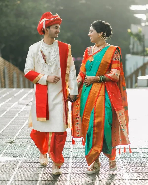 A stunning portrait of a couple in full traditional Maharashtrian wedding attire. The vibrant colors of the nauvari saree and the groom's pheta make for a powerful and culturally rich image.