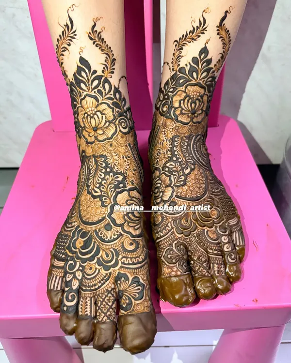 A full view of this intricate floral foot mehendi, with the design covering the top of the feet and toes.