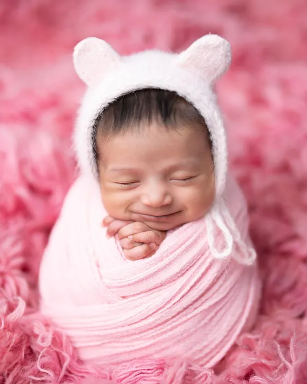 The sweetest smile on this little one, wrapped snugly in pink. I use high-quality, soft fabrics to ensure your baby is comfortable and content throughout the session.