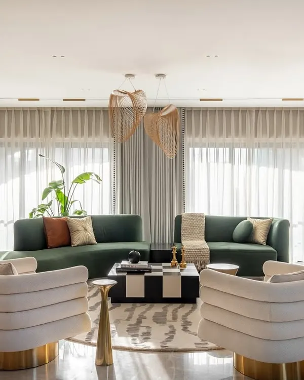 This living area from our award-winning Evelyn penthouse project embodies my philosophy of warm minimalism. The custom curved sofa in emerald green, sculptural lighting, and a mix of textures create a space that is luxurious yet deeply inviting, perfect for both quiet evenings and lively conversations.