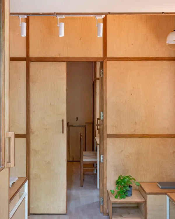 The interior of the 'Urban Sanctuary' clinic in Pune uses warm plywood panels and built-in furniture to create a calming, non-clinical atmosphere.