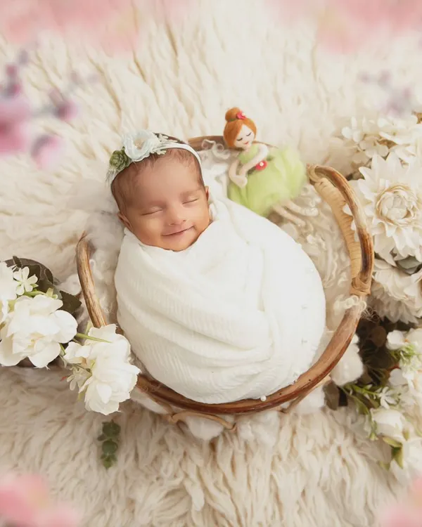 This is the magic I strive to capture. A fleeting, peaceful smile from a newborn, swaddled safely and surrounded by soft, delicate flowers. These are the moments that become timeless art.