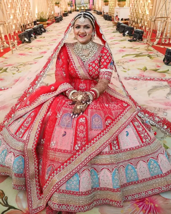 This is what bridal dreams are made of. I created a truly regal look for this stunning bride in her magnificent red lehenga, ensuring every detail was perfect for her grand entrance. This is a classic Rajasthani bridal makeup look that feels both timeless and royal.