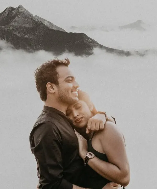 Above a sea of clouds on a misty mountain, this couple's embrace feels like the only thing in the world. This black and white portrait focuses purely on the serene, powerful emotion of their bond during their outdoor couple photoshoot.