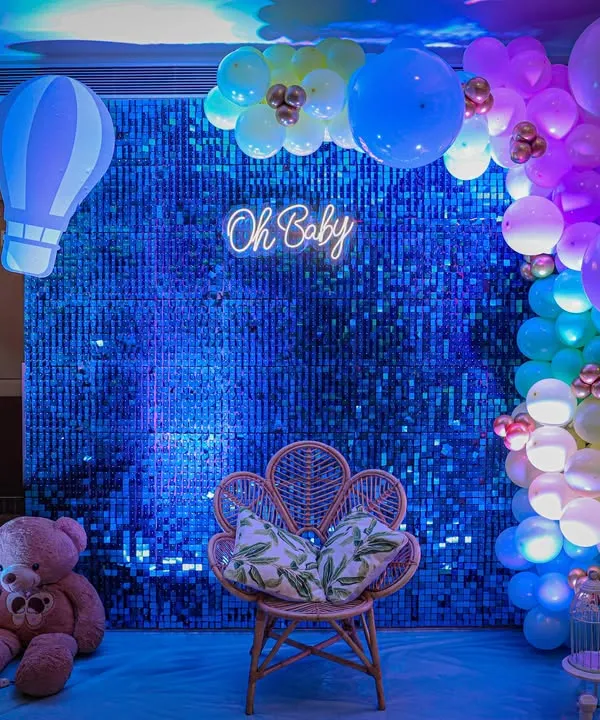 Modern, chic, and totally Instagrammable. This "Oh Baby" setup features a sparkling blue sequin wall, a trendy neon sign, and a gorgeous peacock chair, making the mom-to-be feel like a true queen on her special day.