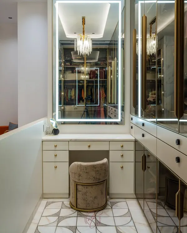 This is the epitome of closet goals. A dedicated vanity with a large, backlit mirror is perfectly integrated into this luxurious walk-in closet, complete with a plush stool and ample drawer space.