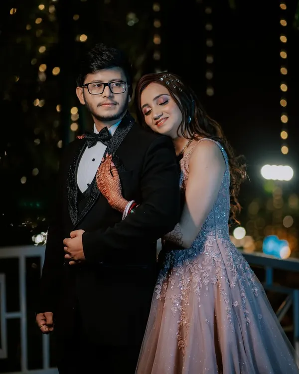A romantic reception portrait under the stars. The bokeh from the fairy lights creates a magical, dreamy background, perfect for capturing the couple's quiet moment together after the wedding ceremony.