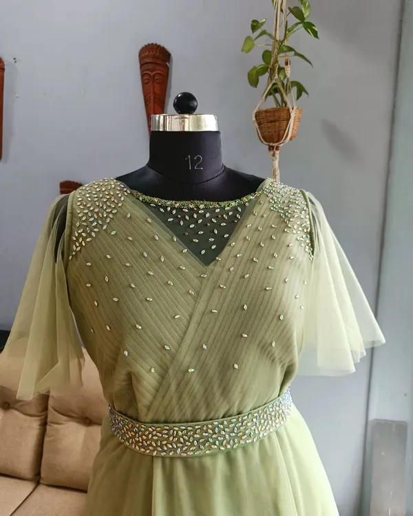 A closer look at the bodice of a student's final gown, featuring a sheer neckline and hand-placed embellishments. This level of detail is a hallmark of the skills we teach.