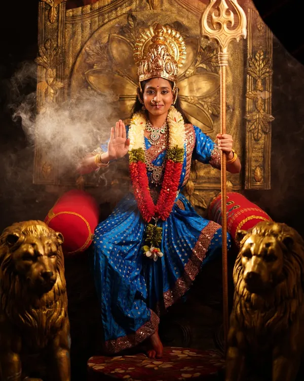 Embody divine power with this complete Devi costume, featuring a traditional blue saree, a golden crown, and a trident prop, all set against a dramatic, smoky background.