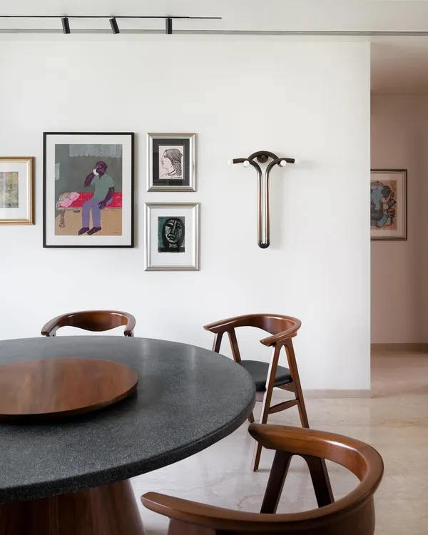 A closer look at the art-filled dining space in our Collectors House. The custom terrazzo and teak dining table is surrounded by classic chairs, with a gallery wall and a unique sculptural piece adding layers of personality.