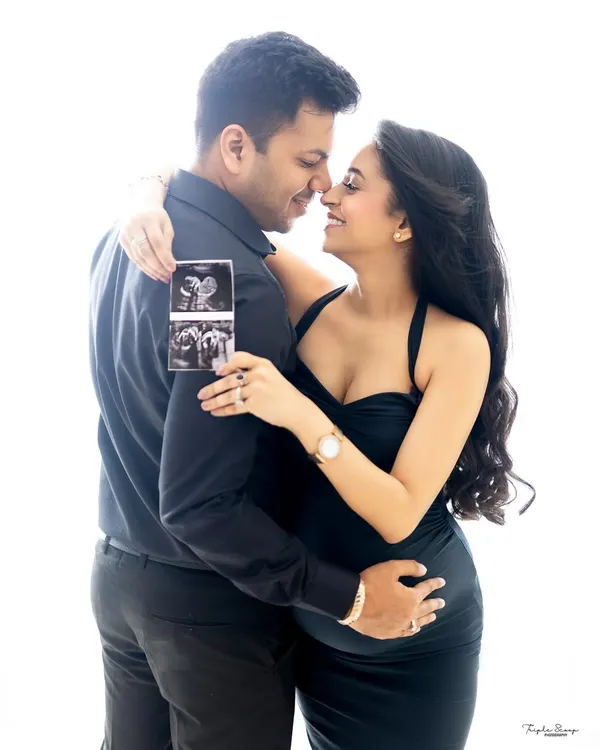 A classic couple's maternity portrait celebrating their upcoming arrival. Holding the sonogram picture adds a deeply personal and exciting touch to the announcement.