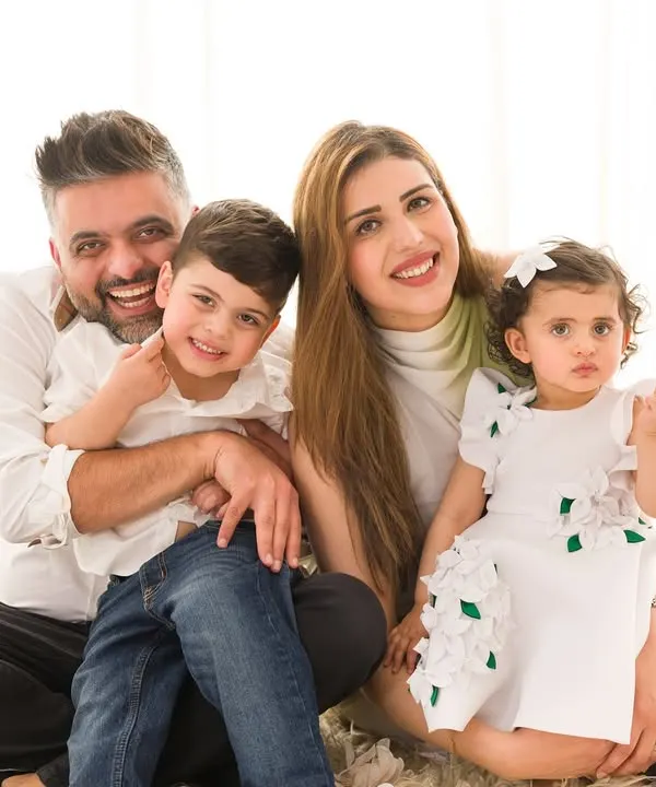 A warm and happy family portrait. The parents and their two children are all smiles in this classic, light-filled image.