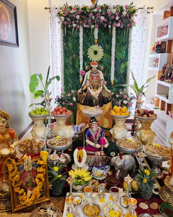 A complete setup for a Varamahalakshmi puja at home. I used a banana leaf backdrop, a floral arch, and a detailed arrangement of offerings and idols to create a sacred space in the living room.