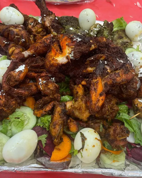 This platter shows the variety of starters I can provide, from whole chicken legs to smaller tikka pieces and kebabs, garnished with eggs and salad.