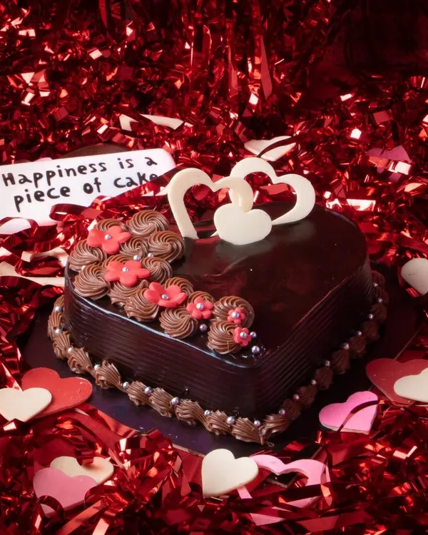 Our 'Love you Forever' Valentine's Cake is a heart-shaped Dutch truffle masterpiece. Adorned with delicate flowers and chocolate hearts, it's the perfect centerpiece for a romantic celebration.