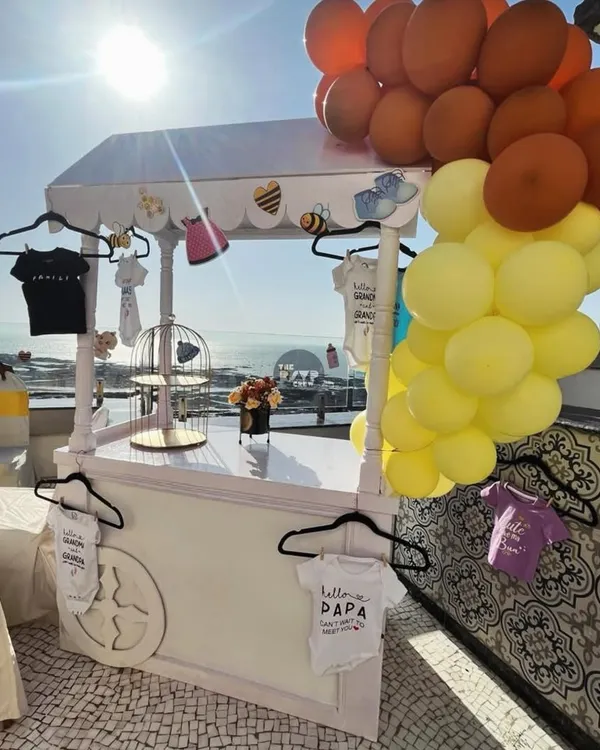 We styled this custom cart for a "Sweet as Can Bee" shower, complete with a balloon cascade and hangers for displaying adorable themed baby onesies. It's a perfect station for gifts, desserts, or just as a unique photo prop.