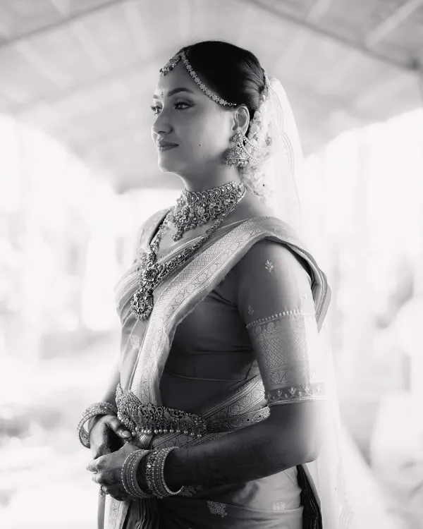 A stunning black and white portrait of the bride, Mohita. Her thoughtful expression and the beautiful details of her South Indian bridal attire are captured in soft, natural light.