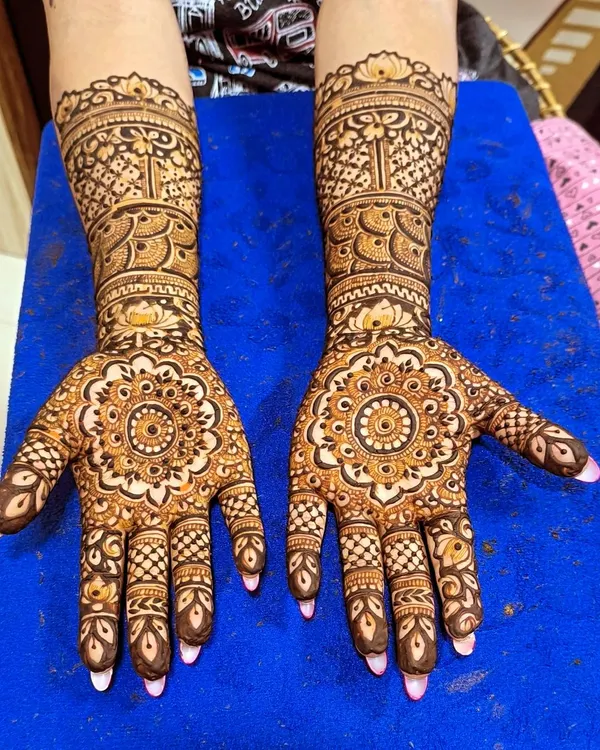 A perfect example of traditional Indian mehendi, featuring a central mandala design on the palm. This symmetrical style is timeless and elegant.