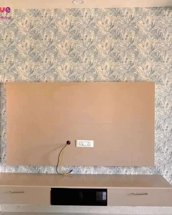 A well-chosen wallpaper can serve as the perfect backdrop. This modern botanical print installed behind a TV console adds visual interest without overwhelming the living room space.