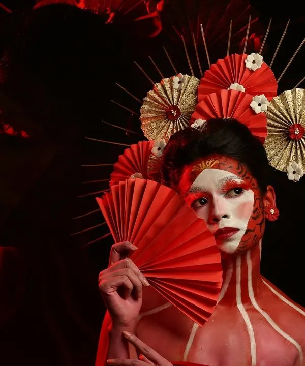 Another angle from our Geisha-inspired creative shoot. The use of dramatic red lighting and shadows adds depth and mystery to the portrait, highlighting the intricate makeup and headpiece.